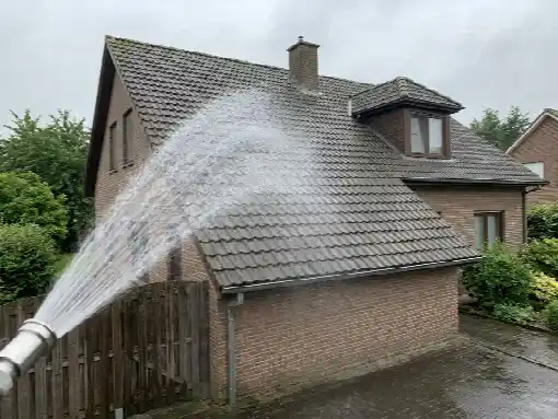 Rinçage doux d'une toiture en tuiles béton, jet large de haut en bas